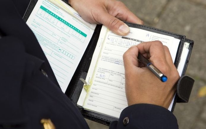 Een politieagent schrijft een boete uit. Foto: ANP