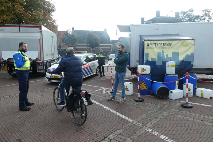 Een voorbij fietsende bezoeker in gesprek met een boa over drugscriminaliteit.