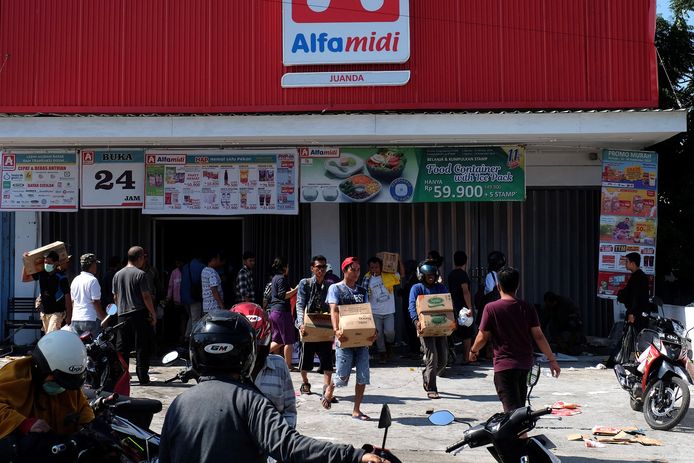Mensen plunderen winkels in Palu. De overheid staat het voorlopig toe.