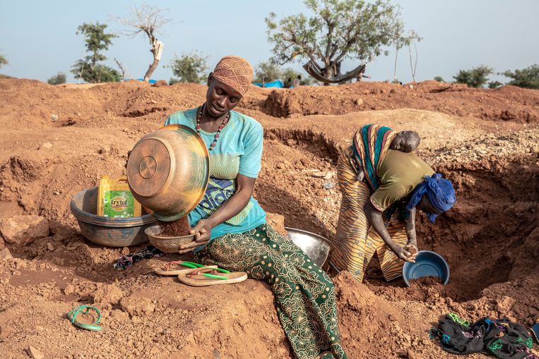 Vrouwen, sommigen met hun kind op de rug gebonden, zoeken naar goud in Zam. De toenemende armoede drijft steeds meer Burkinezen naar de mijnen.  Beeld 