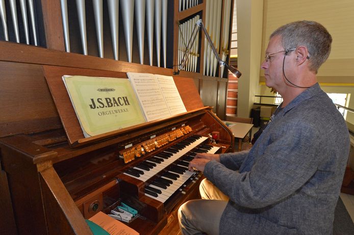 Jan van den Brand achter het orgel van de Julianakerk. Hij is coördinator van de orgeldag.