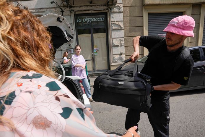 Oleg Psioek mette una borsa nel bagagliaio di un taxi in attesa.