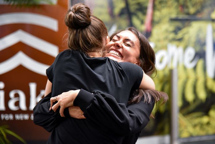 Twee vrouwen omhelzen elkaar op de luchthaven van Wellington nadat de reisbubbel tussen Nieuw-Zeeland en Australië in april werd geopend. Inmiddels is die bubbel weer gesloten door corona-uitbraken in beide landen.