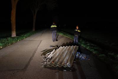 Asbestplaten en zakken vuil midden op een weg gedumpt in Haarsteeg
