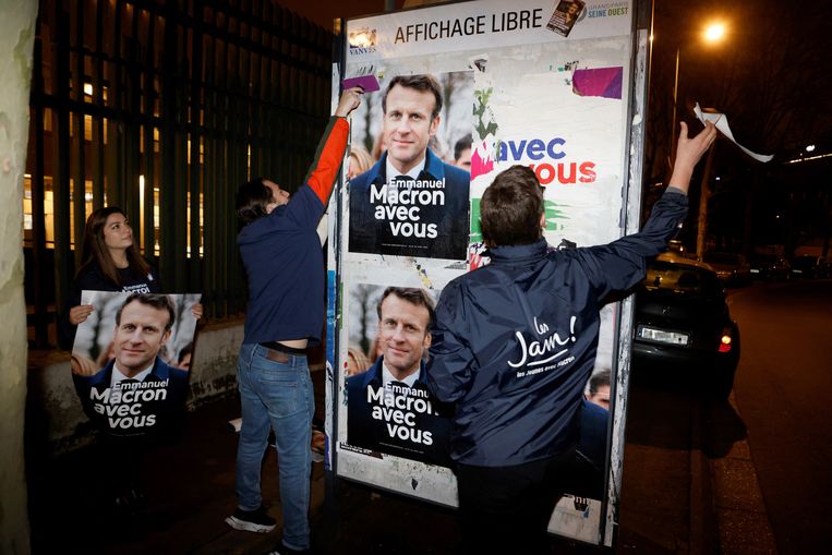 Een plak­team van Macron aan het werk in Vanves.  Beeld AFP