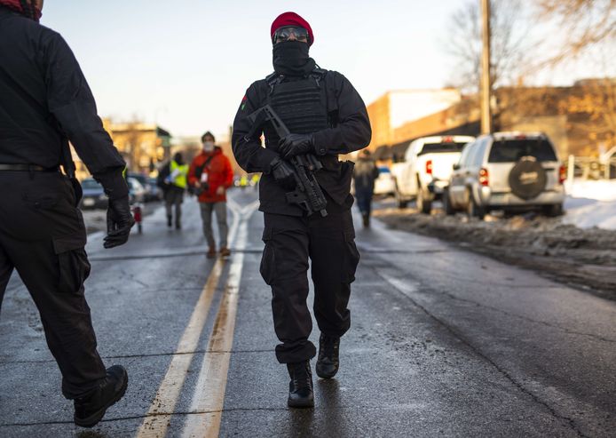 Een gewapende activist van de New Black Panther Party patrouilleert bij de demonstratie.