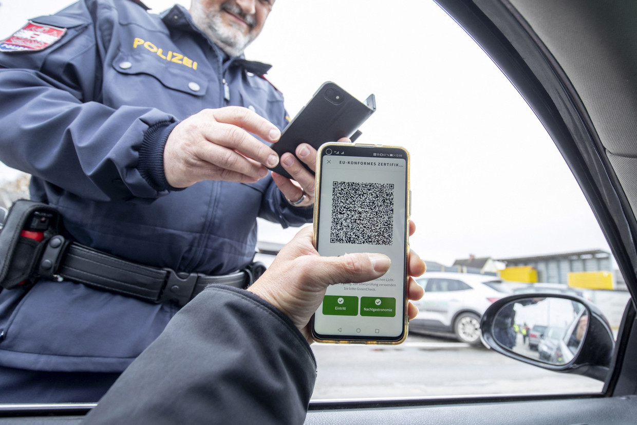 Een Oostenrijkse politiieagent checkt het Covid Safe Ticket van een autobestuurder tijdens een verkeerscontrole in Graz.  Beeld AFP