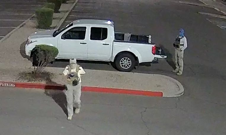Twee gewapende mannen met maskers en kogelvrije vesten bij het stembureau van Mesa in Arizona. Beeld AFP