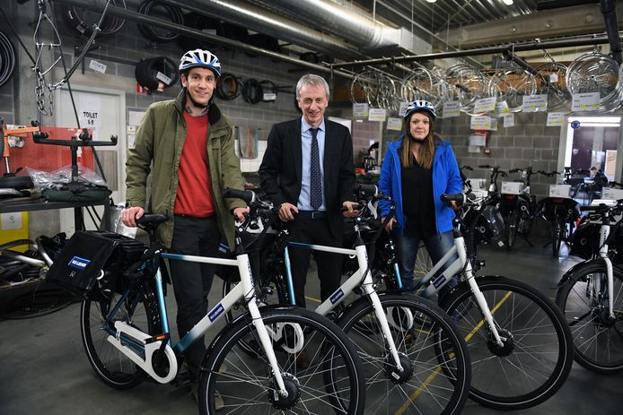 De twee personeelsleden die zich het eerst aanmeldden ontvingen hun e-bike uit handen van vicerector Gerard Govers (midden).