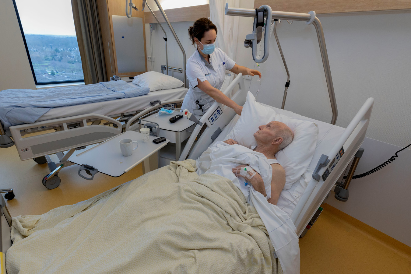 Verpleegkundige Miriam helpt Arno Naethuijs, die net is geopereerd.
