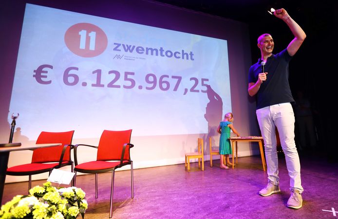 Maarten van der Weijden met het totaalbedrag van de donaties tijdens de huldiging in zijn woonplaats. De succesvolle Elfstedenzwemtocht werd gevierd met een rondrit, onder toeziend oog van toegestroomde fans.