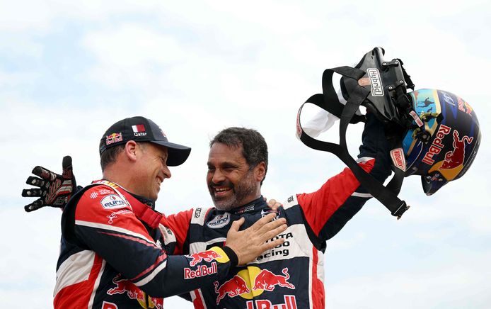 Staande boven op hun Toyota vieren Nasser Al-Attiyah (rechts) en zijn navigator Mathieu Baumel de eindzege.