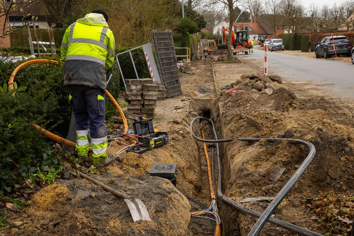 Een technieker legt glasvezelkabels, beeld ter illustratie