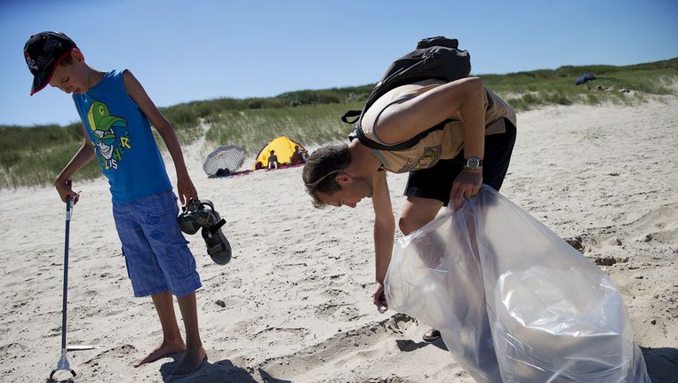 Vrijwilligers verzamelen afval op het strand bij Cadzand. Beeld anp