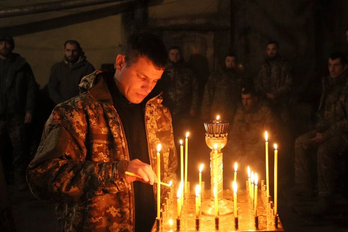 Illustratiebeeld: een Oekraïense soldaat steekt kaarsen aan tijdens een ceremonie in de aanloop naar Kerstmis.