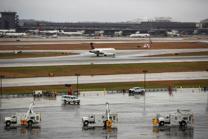 Een vliegtuig van Delta Airlines is zojuist geland in Atlanta in de Amerikaanse staat Georgia, terwijl vrachtwagens met anti-vries klaarstaan om de vleugels van vertrekkende vliegtuigen te ontdooien.