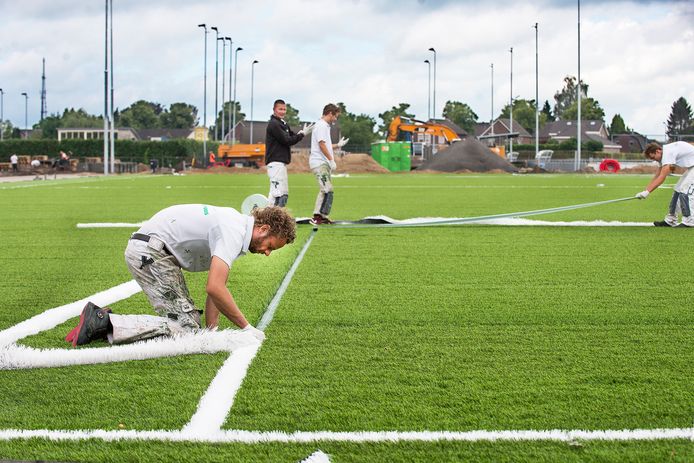 Terwijl op de achtergrond het terrein wordt klaargemaakt voor de aanleg van  twee gewone  voetbalvelden, wordt hier de laatste hand gelegd aan een nieuw kunstgrasveld.
