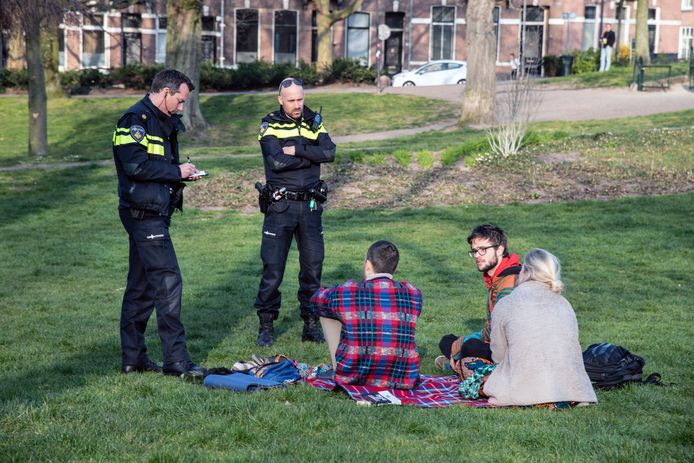 Agenten schrijven een boete uit aan jongeren in een park in Nijmegen.