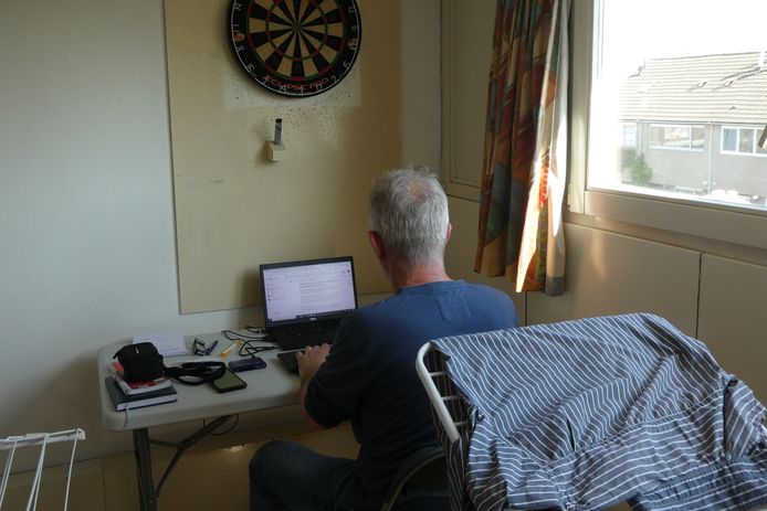 Verslaggever Domien van der Meijden zit tussen het wasgoed en onder het dartbord te werken.