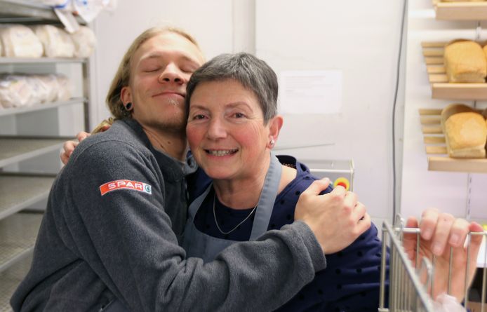 Werknemers Michaël en Annie geven elkaar een stevige knuffel.