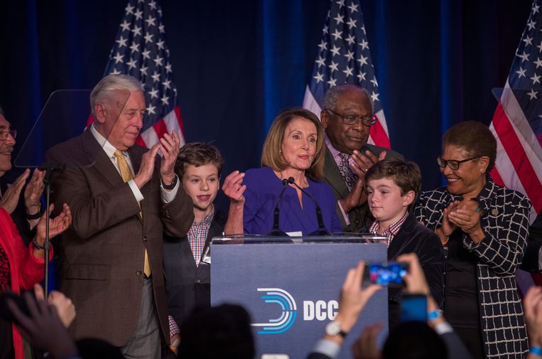 Nancy Pelosi met haar twee kleinkinderen Paul en Thomas (Michiel Vos’ kroost), omstuwd door Democratische medestanders.  Beeld EPA