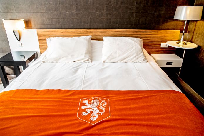 De slaapkamer van de internationals met oranje sprei.