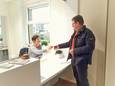 Een van de vrijwillige chauffeurs komt de sleutel van de Handicar ophalen
