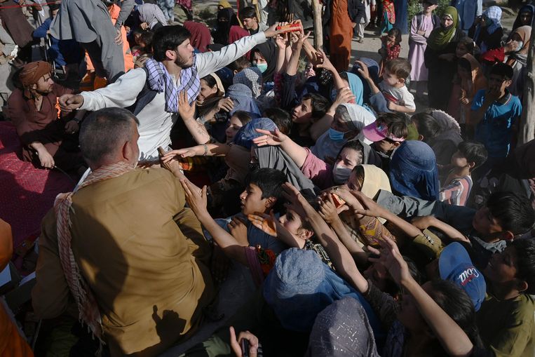 Afghaanse families verzamelen voedsel in Kaboel nadat ze eerder gevlucht zijn uit de provincies Kunduz en Takhar.  Beeld AFP