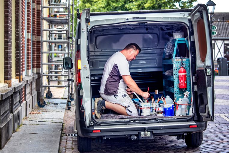 Een schilder/zzp’er aan het werk in zijn busje.  Beeld Raymond Rutting / de Volkskrant 