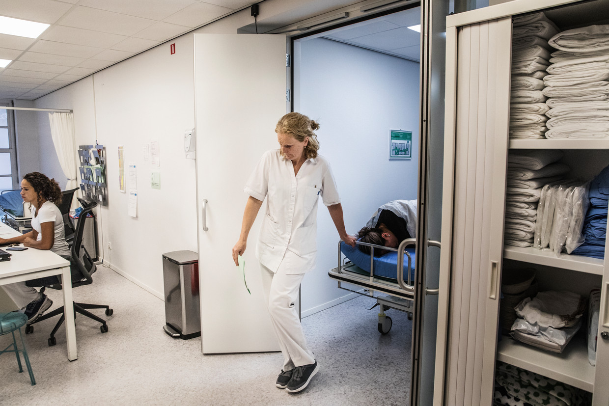 Arts Jorien Nijland rijdt een patiënt naar de zaal in een kliniek in Amsterdam. Beeld Aurélie Geurts