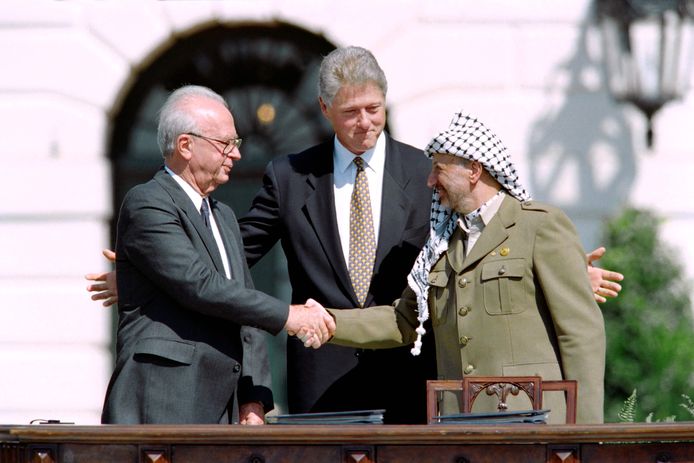 De Amerikaanse president Bill Clinton (M) met leider Yasser Arafat van de Palestijnse Bevrijdingsorganisatie PLO (R) en de Israëlische premier Yitzahk Rabin, na de ondertekening van de Oslo-akkoorden over Palestijnse autonomie in de bezette gebieden, op 13 september 1993.
