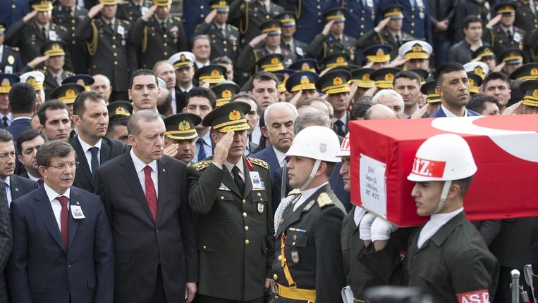 De Turkse premier Ahmet Davutoglu (L), en de Turkse president Tayyip Erdogan (2-L) bij de begrafenis van de soldaat Seckin Cil, die omkwam tijdens de aanslag in Ankara. Beeld epa
