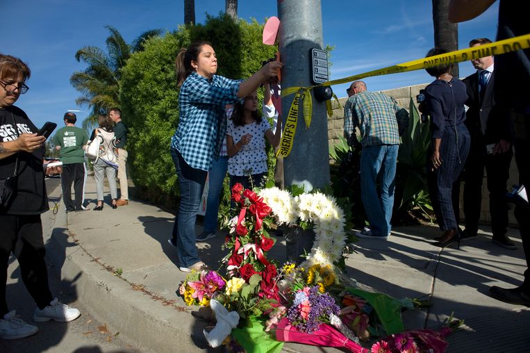 Mensen plaatsen bloemen en steunbetuigingen op een kruispunt naast de synagoge van Chabad of Poway, waar een schutter op 27 april het vuur opende en één persoon doodde in Poway, Californië, VS.  Beeld EPA