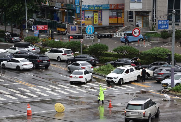 Door het water meegesleurde auto's blokkeren een straat in Seoul.