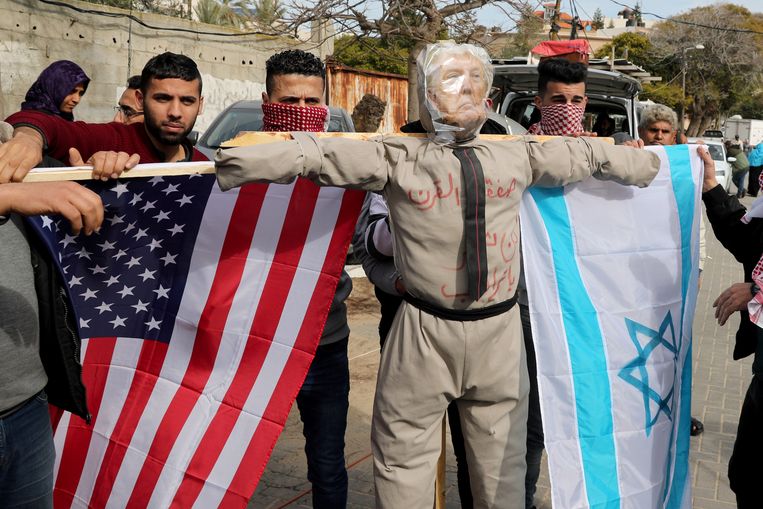 Palestijnen demonstreren tegen de vredesplannen van president Trump. De vlaggen en beeltenis van Trump steken zij in brand. Beeld Reuters