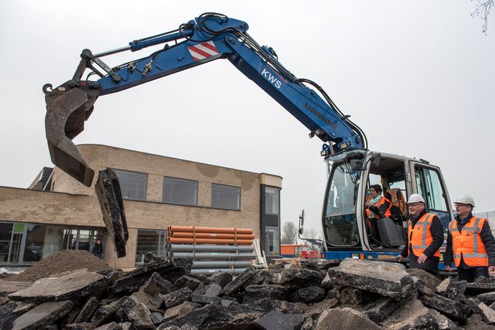Bouw nieuwe brede school is in volle gang. Wethouder Diana van Damme geeft de symbolische start bij de aanleg van het nieuwe parkeerterein (rechts Adri Totté en Frank van Driessche.)