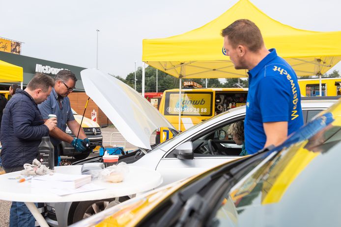 De jaarlijkse vakantiecheck op Hazeldonk. René Nouws (midden) van de Wegenwacht checkt de accu van een auto.