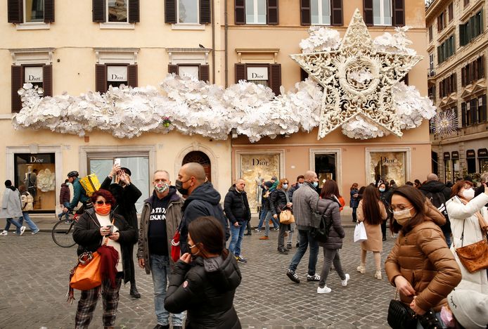 People wear protective masks as they walk on Piazza di Spagna, as the city makes masks mandatory outdoors in busy areas amid a rise in coronavirus cases, ahead of Christmas, in Rome, Italy, December 4, 2021. REUTERS/Remo Casilli