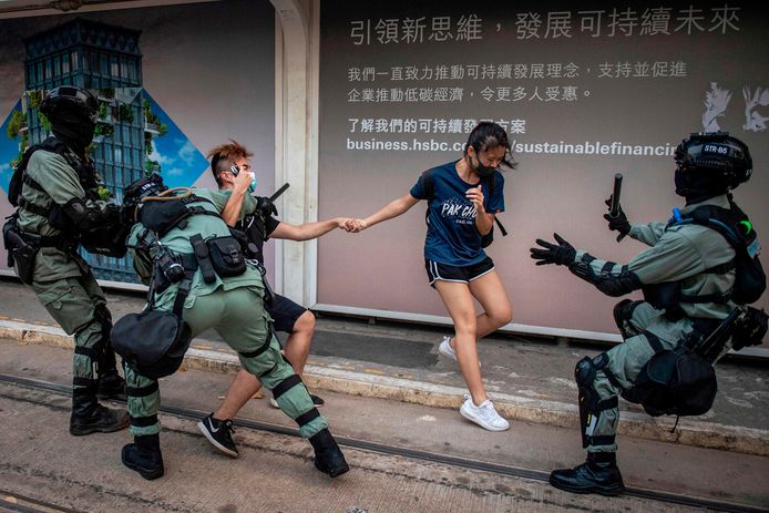 Twee demonstranten worden door de politie tegengehouden in Hongkong.