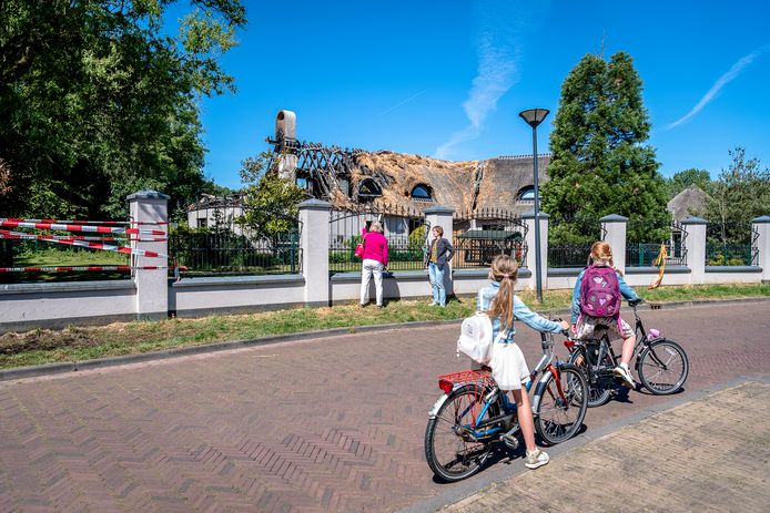 De schade aan de villa aan de ‘s-Gravenweg in Capelle aan den IJssel is enorm. Rond het hek verzamelen buurtbewoners zich om te zien wat er is overgebleven van de woning na de grote brand van donderdag.