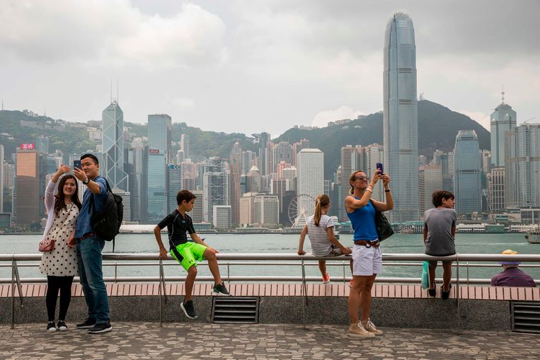 Toeristen nemen selfies in Hongkong. De vroegere Britse kolonie is sinds 1997 onderdeel van China, maar heeft een behoorlijke mate van autonomie, op grond van het beginsel ‘Eén land, twee systemen'. Beeld AFP