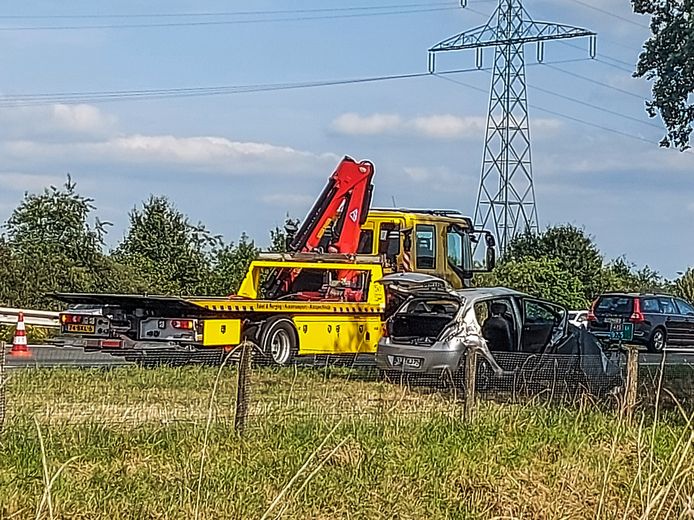 De gehavende auto langs de A73 met de sleepwagen.