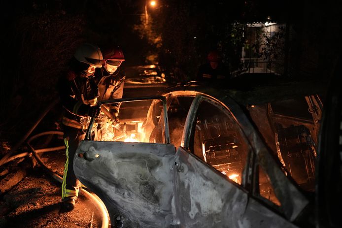 De hulpdiensten blussen een in brand gevlogen auto in Kiev na Russische drone-aanvallen afgelopen nacht.