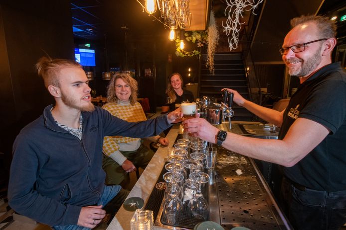 Johan Luijkman (rechts) reikt Jelte Beersma een biertje aan. Ester, moeder van Jelte en Marlie Engel zitten ook aan de bar van Station Royaal.