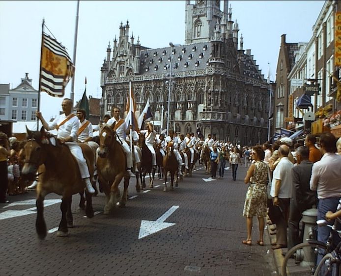 Optocht van ringrijders op de Markt in Middelburg, halverwege de jaren zeventig. Beeld uit een van de ‘Middelburgs Mozaïek’-films. Deze is gemaakt door Cor Dees.