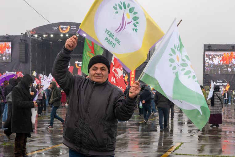 Abdusamed Solmaz deelt vlaggen uit van de Groen Links Partij op de bijeenkomst ter viering van Newroz, het Koerdische Nieuwjaar. Beeld Ingrid Woudwijk 