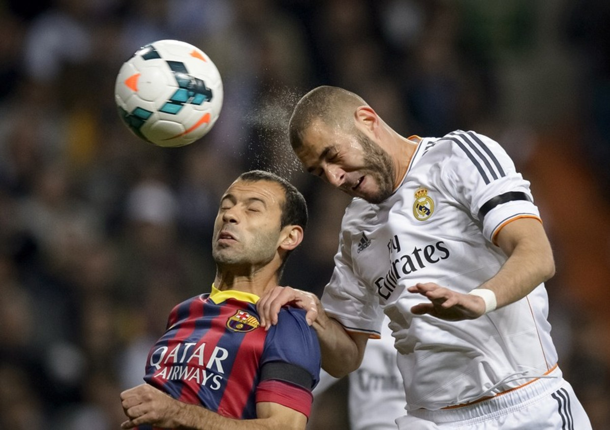 Benzema torent boven Barcelona-speler Mascherano uit en kopt de 1-0 binnen Beeld afp