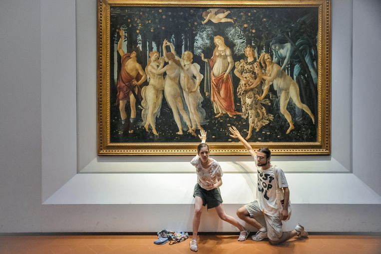 Actievoerders van Ultima Generazione hebben zich vastgelijmd aan het werk ‘Primavera’ van Sandro Botticelli in het Uffizi in Florence. Hun handen zaten vast aan het glas voor het paneel. Beeld Getty Images