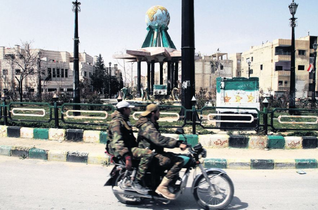 Syrische militairen rijden een rondje op het centrale plein van Jabroed na de inname van de stad. Beeld ap