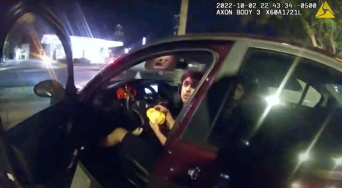 Een verschrikte Erik Cantu zit een hamburger te eten in zijn wagen wanneer agent James Brennand de autodeur opent.